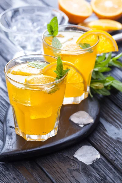 Orangencocktail Mit Eis Und Frischer Minze Auf Einem Schwarzen Holztisch — Stockfoto