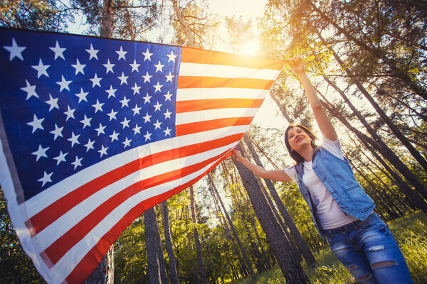 happy smiling young woman with national american flag outdoors. Independence Day, 4th July