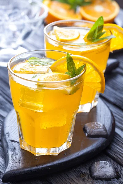 Orangencocktail Mit Eis Und Frischer Minze Auf Einem Schwarzen Holztisch — Stockfoto