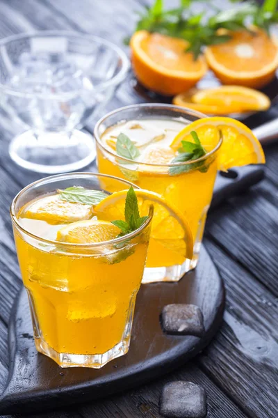 Orangencocktail Mit Eis Und Frischer Minze Auf Einem Schwarzen Holztisch — Stockfoto