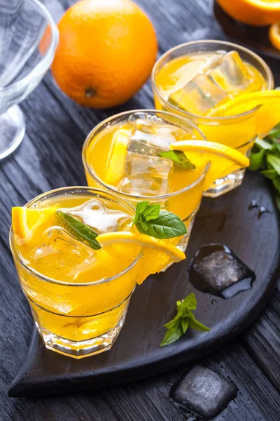 Orangencocktail Mit Eis Und Frischer Minze Auf Einem Schwarzen Holztisch — Stockfoto