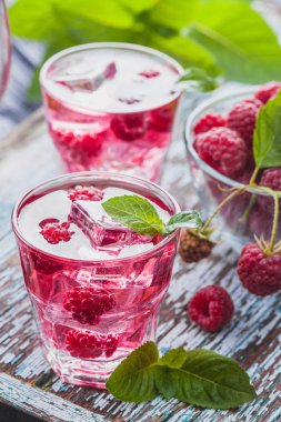 Kırmızı Ahududu buz ve eski ahşap bir masa üzerinde taze nane kokteyli. canlandırıcı yaz içeceği