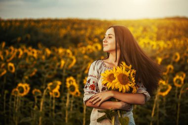 Şirin esmer bir ulusal Ukrayna giyim ayçiçeği çiçek açması alanında. kırsal mutlu yaşam