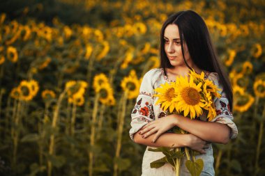 Şirin esmer bir ulusal Ukrayna giyim ayçiçeği çiçek açması alanında. kırsal mutlu yaşam