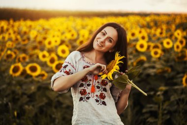 Şirin esmer bir ulusal Ukrayna giyim ayçiçeği çiçek açması alanında. kırsal mutlu yaşam
