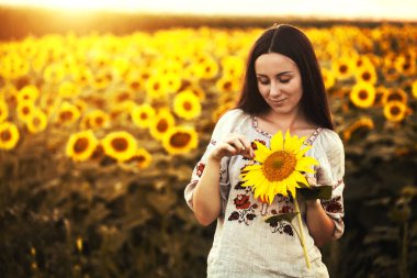 Şirin esmer bir ulusal Ukrayna giyim ayçiçeği çiçek açması alanında. kırsal mutlu yaşam