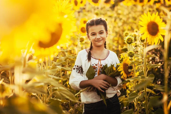 国立ウクライナ洋服のヒマワリ開花フィールドでかわいい子は 農村の幸せな生活 — ストック写真