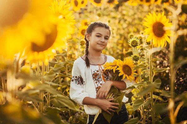 国立ウクライナ洋服のヒマワリ開花フィールドでかわいい子は 農村の幸せな生活 — ストック写真