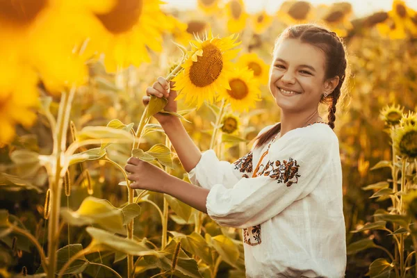 国立ウクライナ洋服のヒマワリ開花フィールドでかわいい子は 農村の幸せな生活 — ストック写真