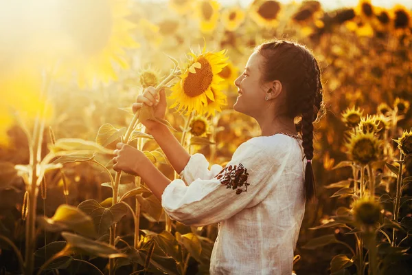 国立ウクライナ洋服のヒマワリ開花フィールドでかわいい子は 農村の幸せな生活 — ストック写真