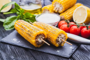 Siyah ahşap masa üzerinde lezzetli ızgara mısır. Üstten Görünüm, mocap