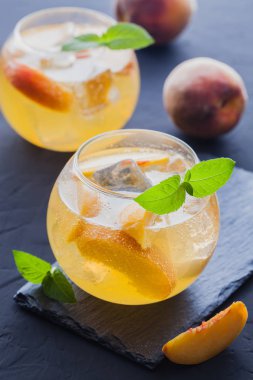 Olgun şeftali buz ve siyah bir tablo taze nane kokteyli. canlandırıcı yaz içeceği