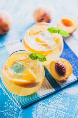 Olgun şeftali buz ve mavi bir tablo taze nane kokteyli. canlandırıcı yaz içeceği