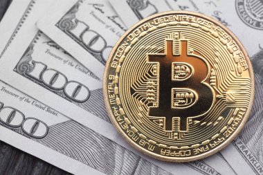 Yakın çekim yüz dolar faturaları üzerinde altın Bitcoin.