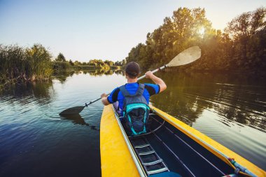Kanocu adam kürek Kayık günbatımı River arka görünümü. Kayak, Kano, kürek çekmeye. Macera aktivite
