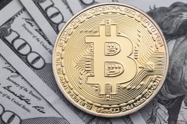 Yakın çekim yüz dolar faturaları üzerinde altın Bitcoin.