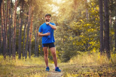 Sakallı bir atlet bir sabah bir pitoresk orman yolu çalıştırmak için hazırlar. sağlıklı yaşam konsepti