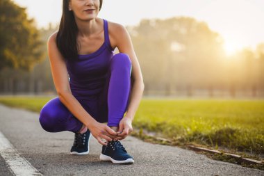 Ayakkabı bağcığı bağlayan kadın sporcu. Sağlıklı yaşam tarzı