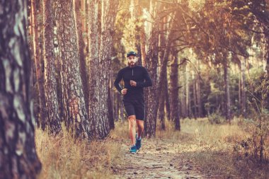 Sakallı bir atlet bir pitoresk orman yolu çalışır. sağlıklı yaşam konsepti