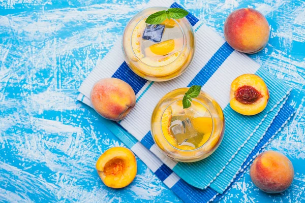 熟した桃のアイスと青いテーブルに新鮮なミント カクテル さわやかな夏の飲み物 — ストック写真