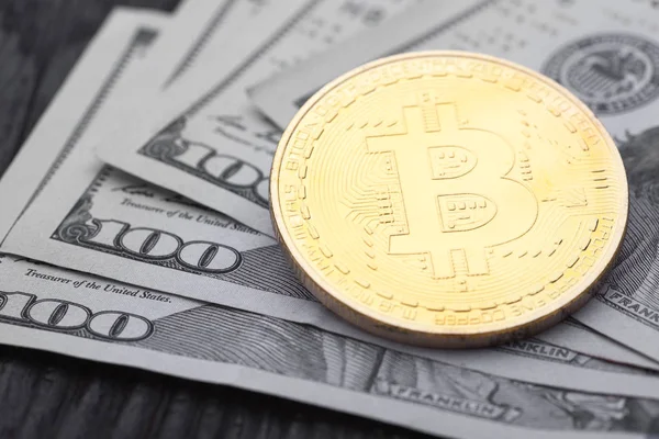 Yakın çekim yüz dolar faturaları üzerinde altın Bitcoin.