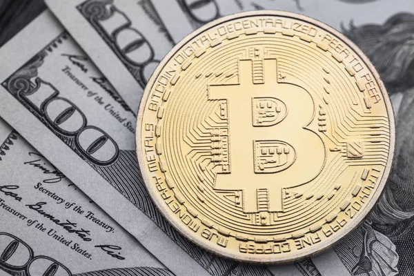 Yakın çekim yüz dolar faturaları üzerinde altın Bitcoin.