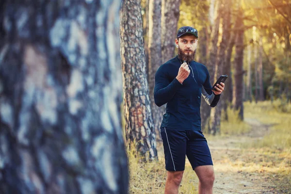 A bearded athlete runs along a picturesque forest path. healthy lifestyle concept