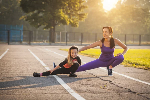 妈妈和女儿在上午的运动训练中做热身 健康的生活方式 — 图库照片