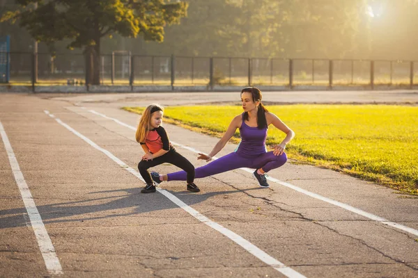 妈妈和女儿在上午的运动训练中做热身 健康的生活方式 — 图库照片