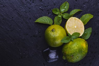 Buz, olgun taze limes siyah arduvaz taş zemin üzerine nane. Kopya alanı ile Üstten Görünüm