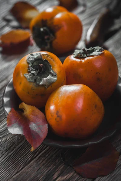 Maturare Frutta Arancio Cachi Foglie Cachi Piatto Marrone Tavolo Legno — Foto Stock