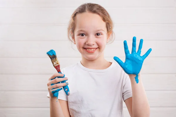 Bella Bambina Con Mani Nella Vernice Blu Sullo Sfondo Legno — Foto Stock