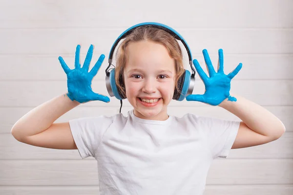 Beautiful Little Girl Headphones Hands Blue Paint White Wooden Background — Stock Photo, Image