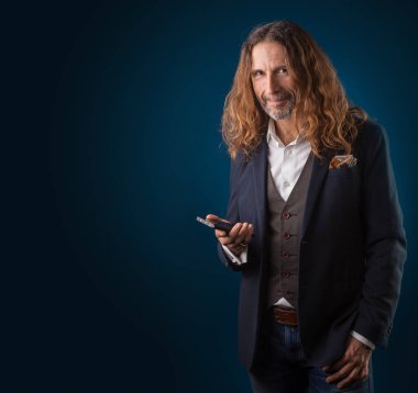 uzun saçlı şık erkek kot pantolon ve ceket mavi bir arka plan üzerinde.