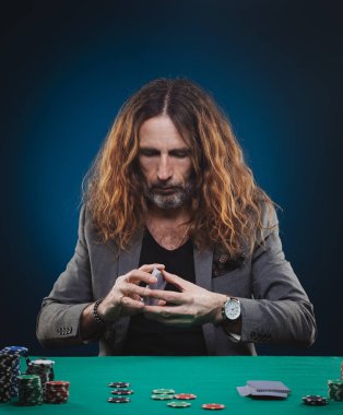 Bir casino poker oynamaya uzun saçlı yakışıklı adam.