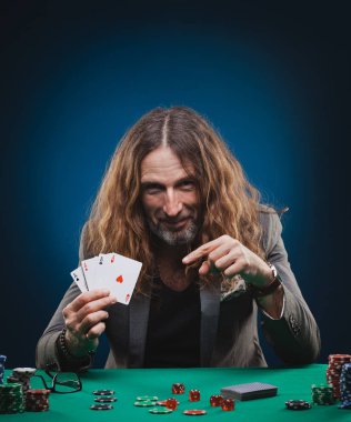 Bir casino poker oynamaya uzun saçlı yakışıklı adam.