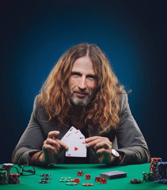 Bir casino poker oynamaya uzun saçlı yakışıklı adam.