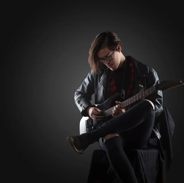 黒の背景にハンサムな演奏ギター — ストック写真