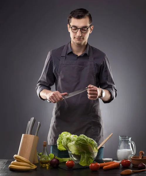 Handsome Man Prepares Delicious Dish Gray Background Studio Photo — Stock Photo, Image