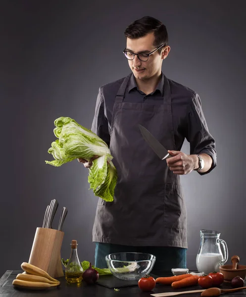 Handsome Man Preparing Delicious Salad Tomatoes Cabbage Gray Background Studio — Stock Photo, Image