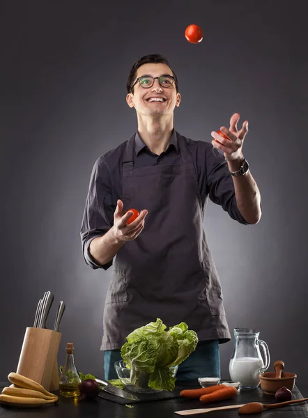 Handsome Man Preparing Delicious Salad Tomatoes Cabbage Gray Background Studio — Stock Photo, Image