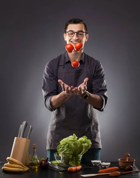 Przystojny Mężczyzna Przygotowuje Pyszne Sałatki Pomidorów Kapusta Szarym Tle Studio — Zdjęcie stockowe