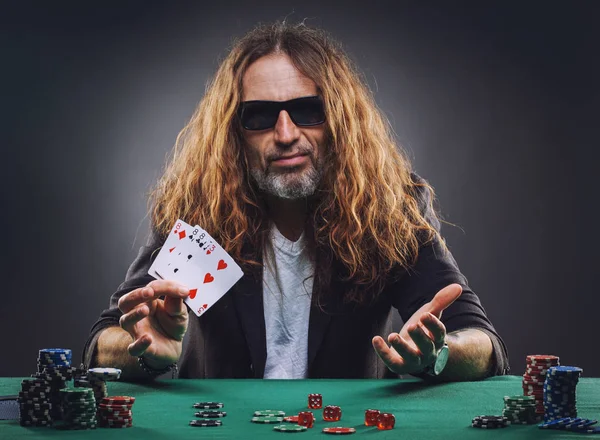Homem bonito de cabelos compridos a jogar poker num casino . — Fotografia de Stock
