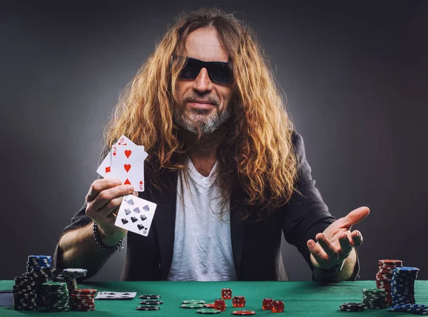 Bello dai capelli lunghi che gioca a poker in un casinò . — Foto Stock