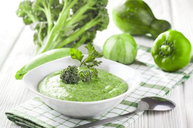 Beyaz ahşap masa üzerinde taze sebze ile Kremalı brokoli çorbası