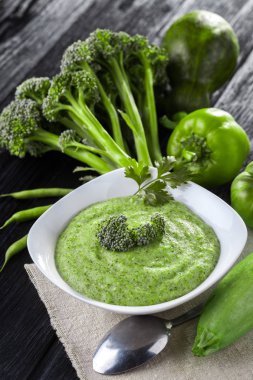 Siyah ahşap masa üzerinde taze sebze ile Kremalı brokoli çorbası