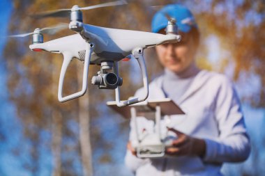 Adam quadrocopter uçuş kontrol eder. Helikopter uçuyor. Bir kadın elinde uzaktan kumanda