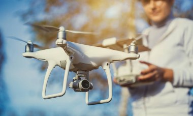 Adam quadrocopter uçuş kontrol eder. Helikopter uçuyor. Bir kadın elinde uzaktan kumanda