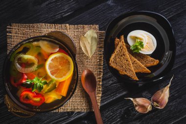 Siyah ahşap arka plan üzerinde bir tencerede taze sebze çorbası