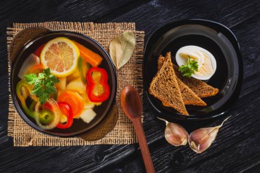 Siyah ahşap arka plan üzerinde bir tencerede taze sebze çorbası